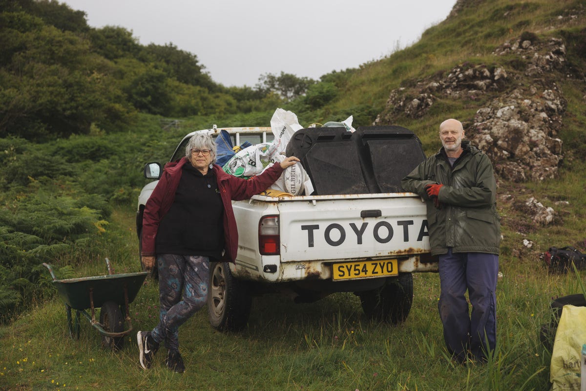 Two people leaning on the back of a pickup truck.