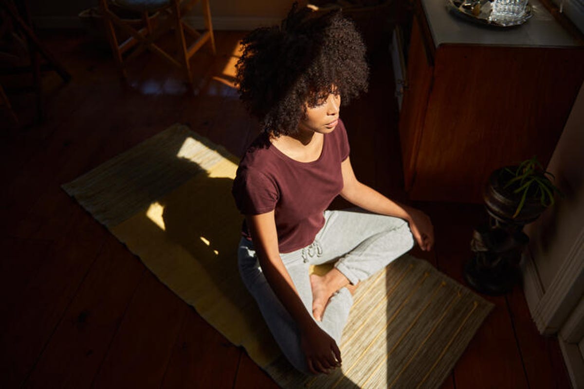 Young woman doing yoga in her bedroom