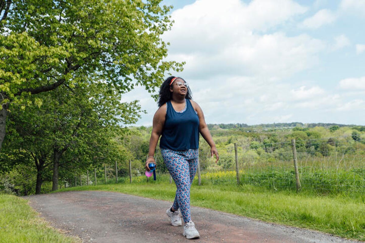 Woman walking outside on a path in the park