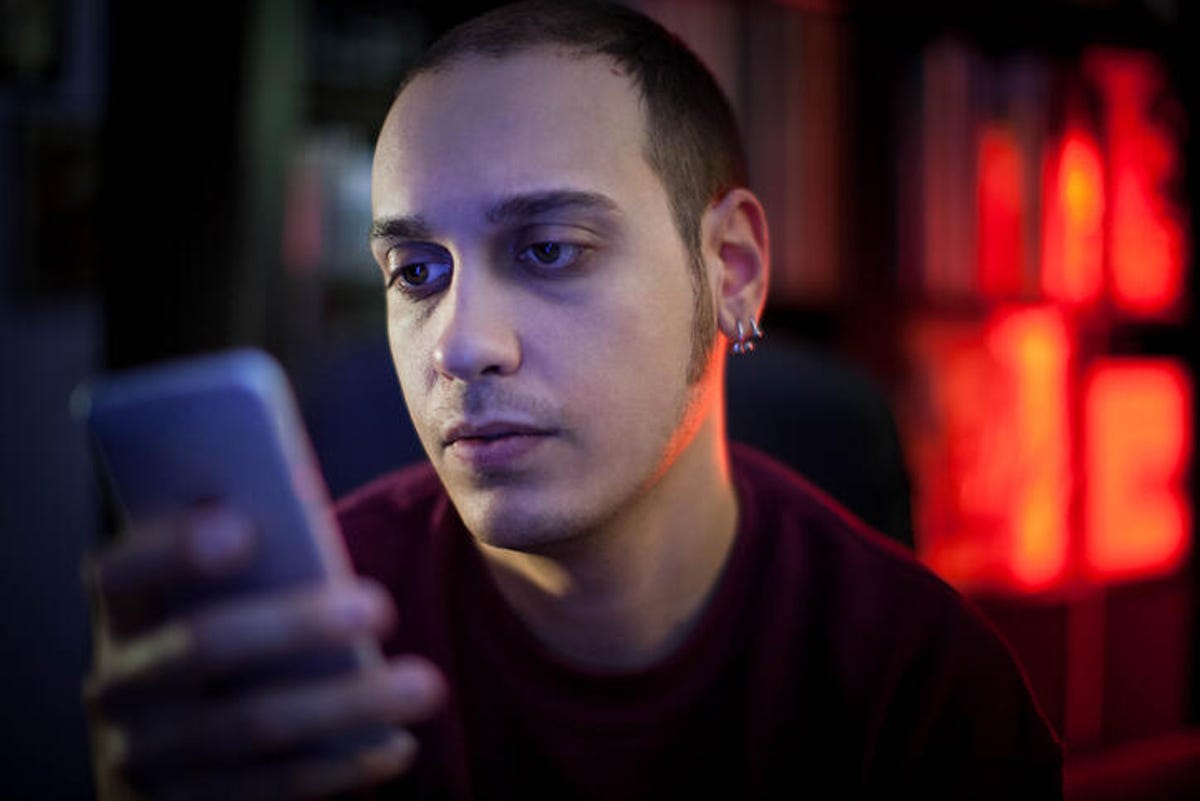Man scrolling through social media on his phone.
