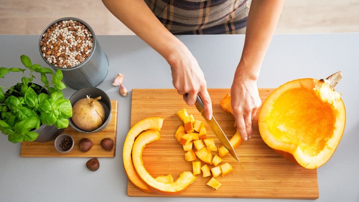 Person cuts up a pumpkin