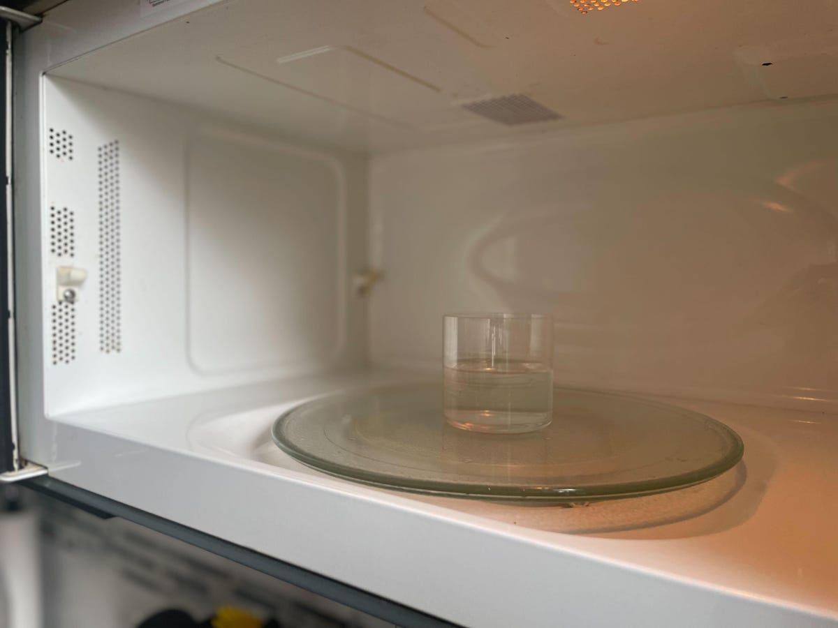 a glass of water sits in a microwave