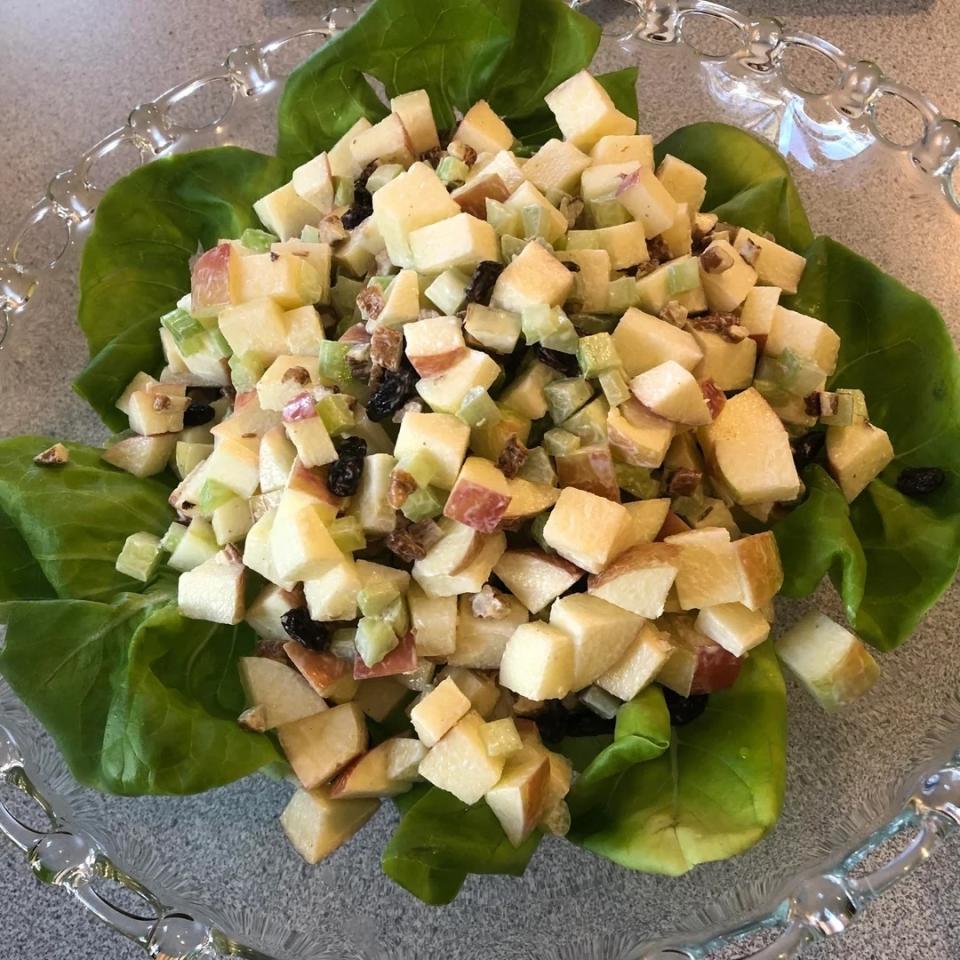 Diced apple salad with nuts and raisins on a bed of lettuce