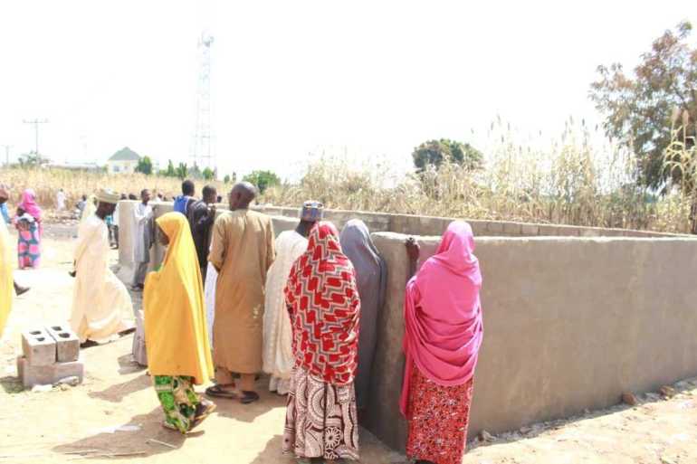 Community members grieve at a mass grave site for victims who died in a fire in Majia, Nigeria [Ali Rabiu Ali/Al Jazeera]
