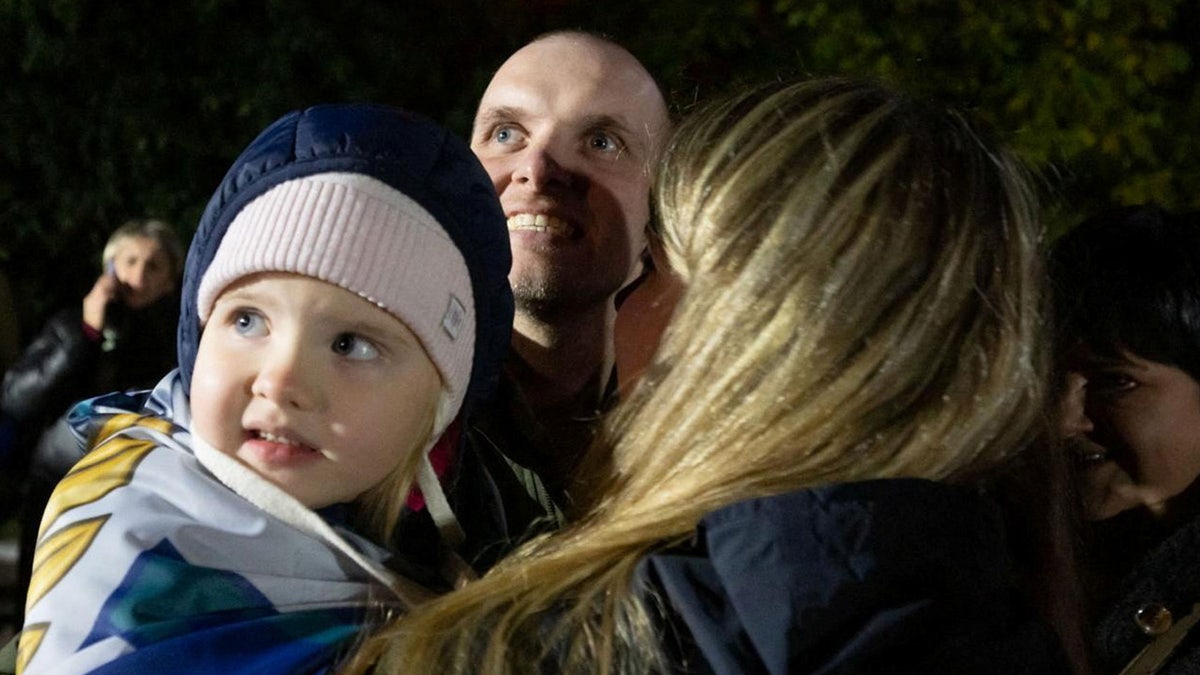 A Ukrainian prisoner of war (POW) stands with his relatives after a swap, amid Russia's attack on Ukraine, in an undisclosed location in Ukraine, in this handout picture obtained on Oct. 19, 2024.