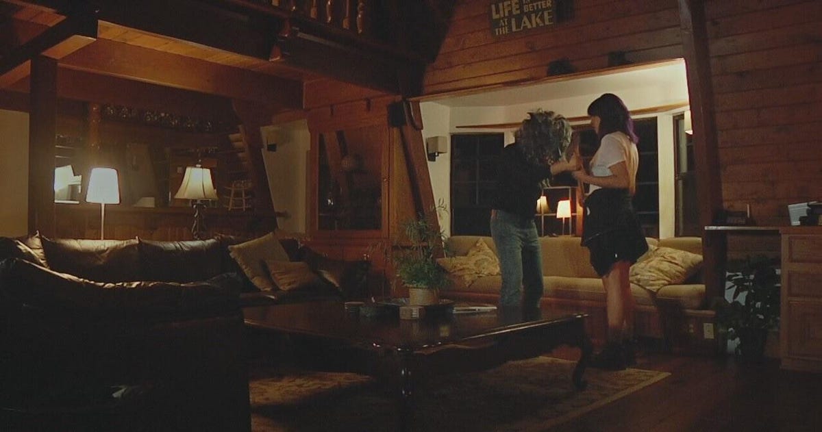 a scene from the movie Creep 2 showing Aaron wearing a scary mask in front of Sara
