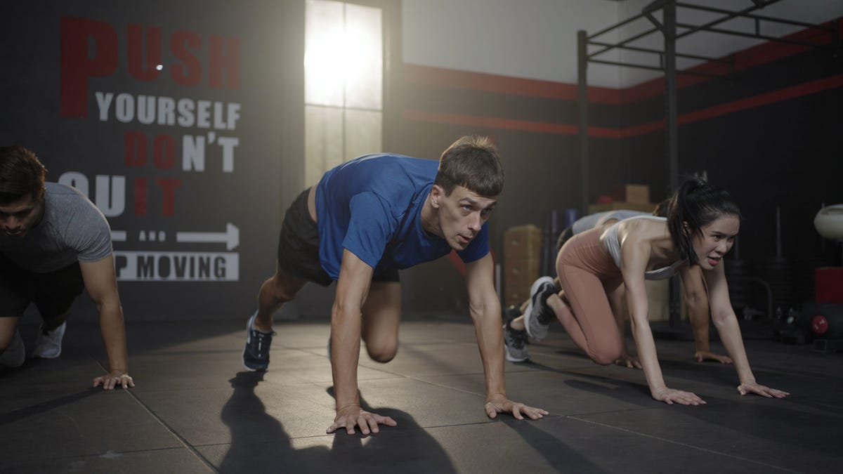 A man does mountain climbers in a group fitness class.