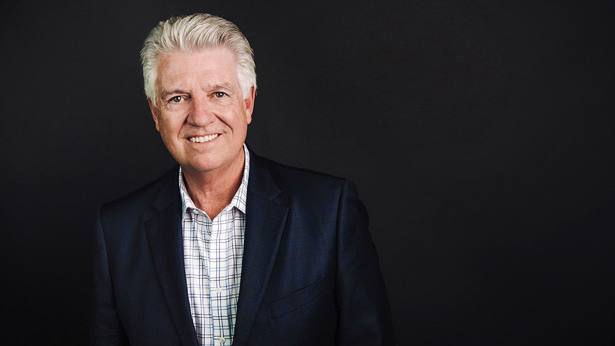 Picture of Dr. Jack Graham, a white man with gray hair, wearing a plaid shirt under a blue blazer. He is smiling.