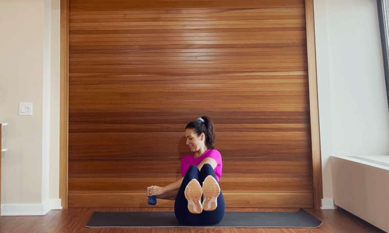 Stephanie Mansour doing kettlebell exercise russian twist