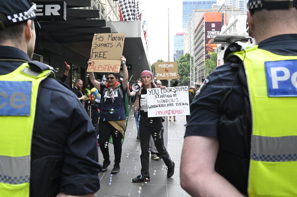 Police officers watch the pro-Palestine protesters outside Myer on Sunday.