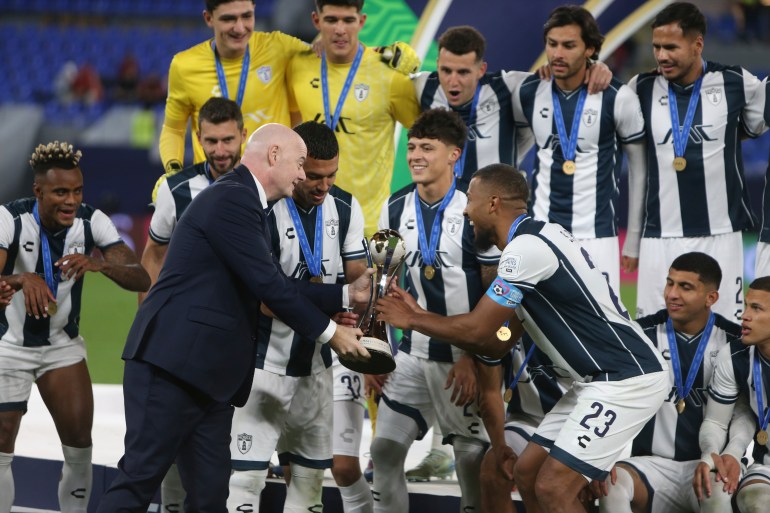 CF Pachuca's Salomon Rondon (23) receives the trophy from FIFA President Gianni Infantino after winning their Intercontinental Cup soccer match against Al Ahly FC at Stadium 974 in Doha, Qatar, Saturday, Dec. 14, 2024. (AP Photo/Hussein Sayed)