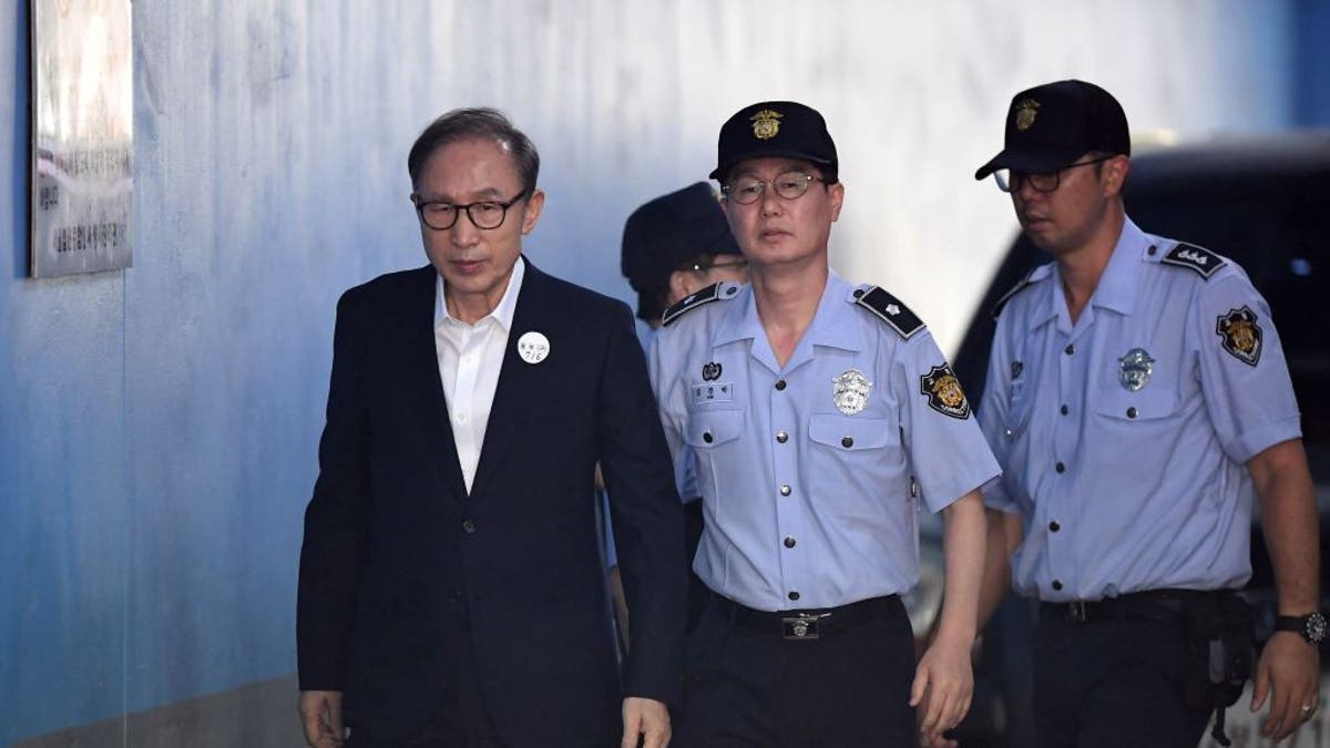 Former South Korean president Lee Myung-bak (L) arrives at a court to attend his trial in Seoul on September 6, 2018. Prosecutors demanded 20 years in prison for former South Korean president Lee Myung-bak for corruption, the last of the country's four living ex-leaders to be embroiled in a criminal inquiry. J