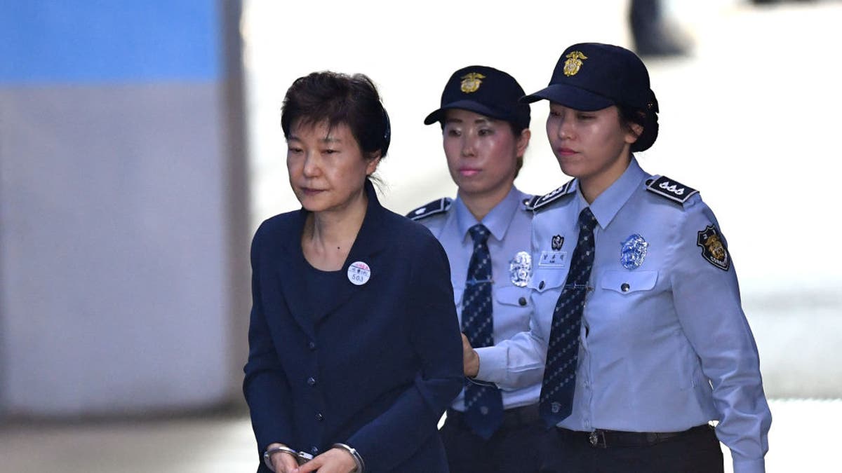 TOPSHOT - South Korean ousted leader Park Geun-Hye (L) arrives at the Seoul Central District Court in Seoul on May 25, 2017, for her trial over the massive corruption scandal that led to her downfall.
