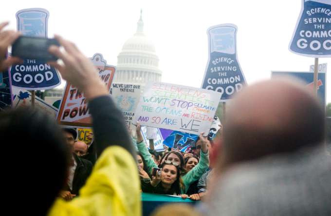 Protesters hold signs in support of science in front of the U.S. Capitol.