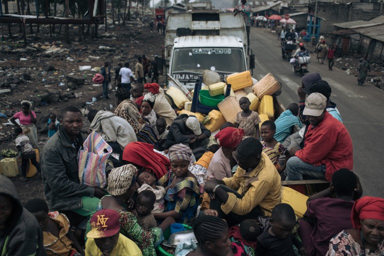 War-displaced people board trucks to leave the camps in Goma.