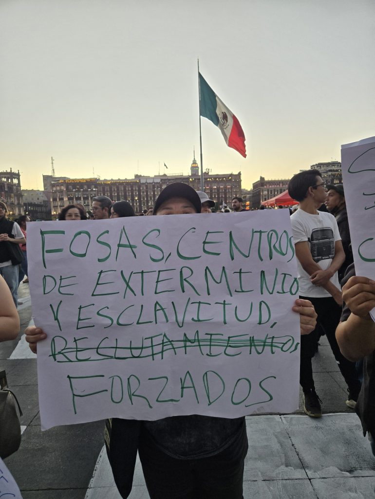 A woman holds up a sign that reads, 