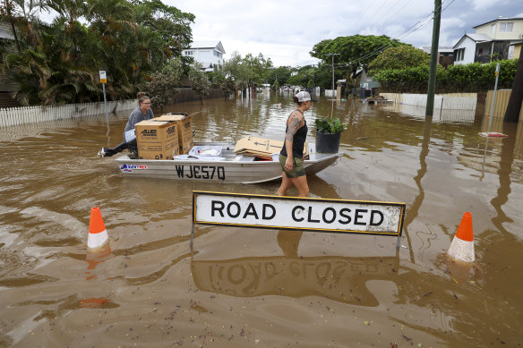 Brisbane’s devastating 2022 floods: Two residents use a boat to save items from their home in Auchenflower.