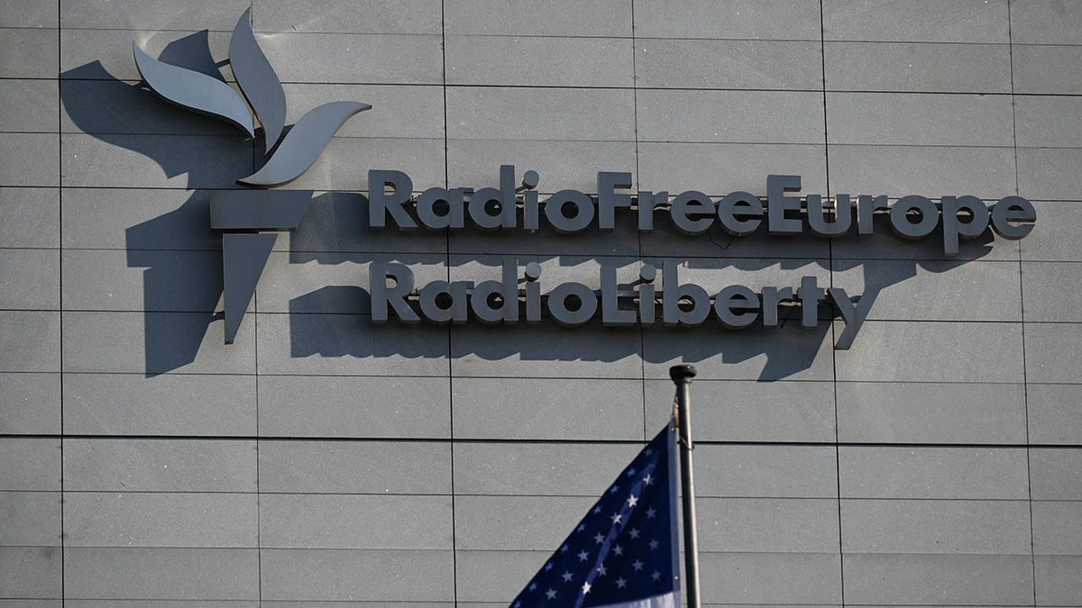 Radio Free Europe/Radio Liberty logo seen by the American flag in Prague