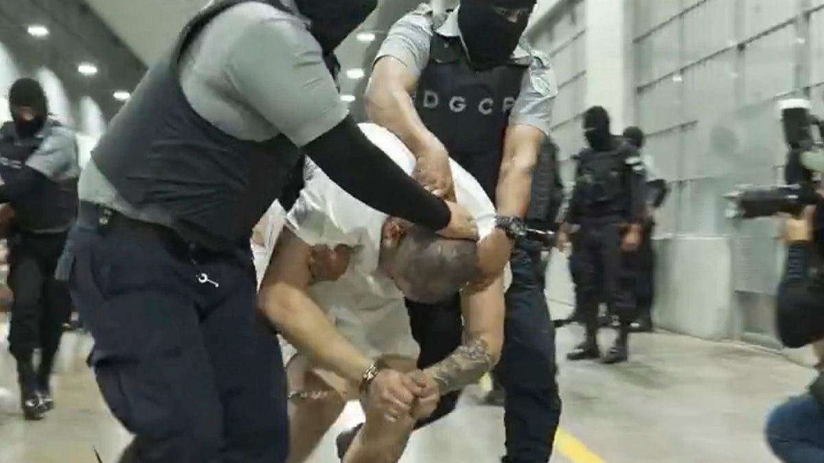Kilmar Abrego Garcia being handled by guards in El Salvador