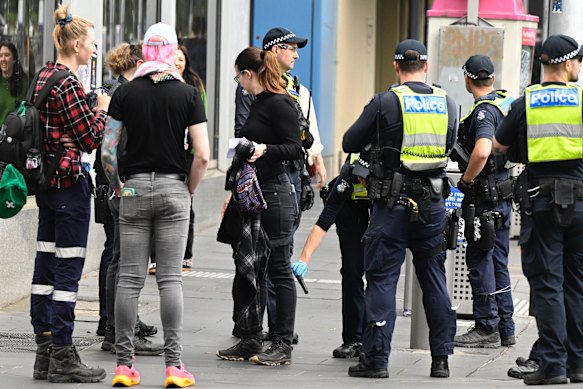 Police search protestors on Spring Street before a planned pro-trans counter rally.