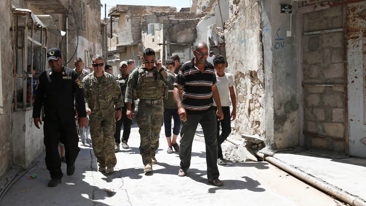 Caine walks through Iraq as a commander in 2018 