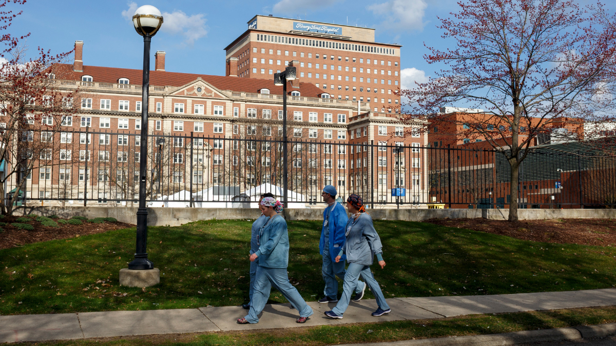 Healthcare workers walk around the perimeter of Henry Ford Hospital on April 8, 2020, in Detroit, Michigan.