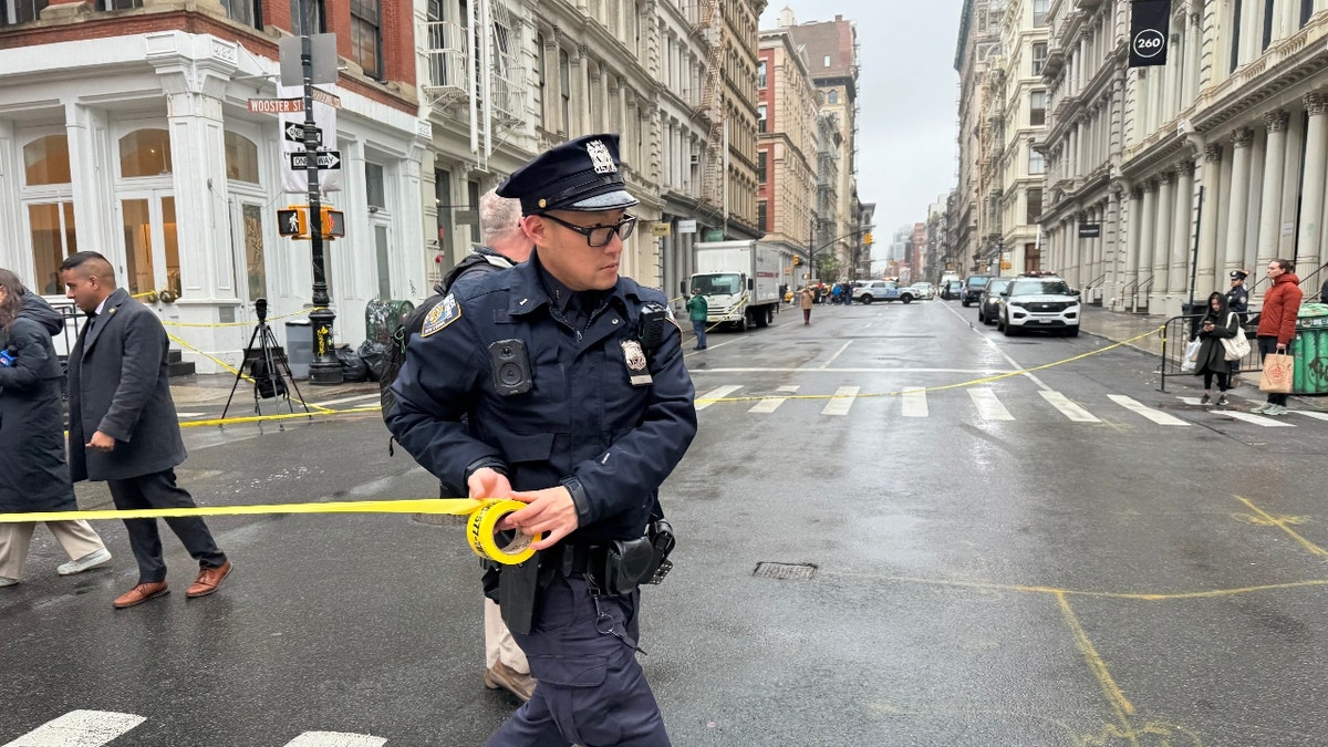 An NYPD officer puts up crime scene tape in Soho after an April 7 stabbing