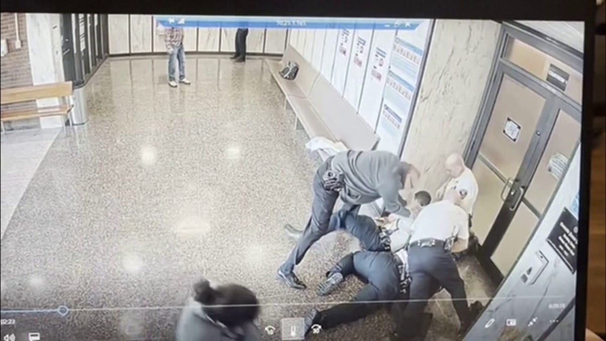 officers swarm the man and subdue him on the ground