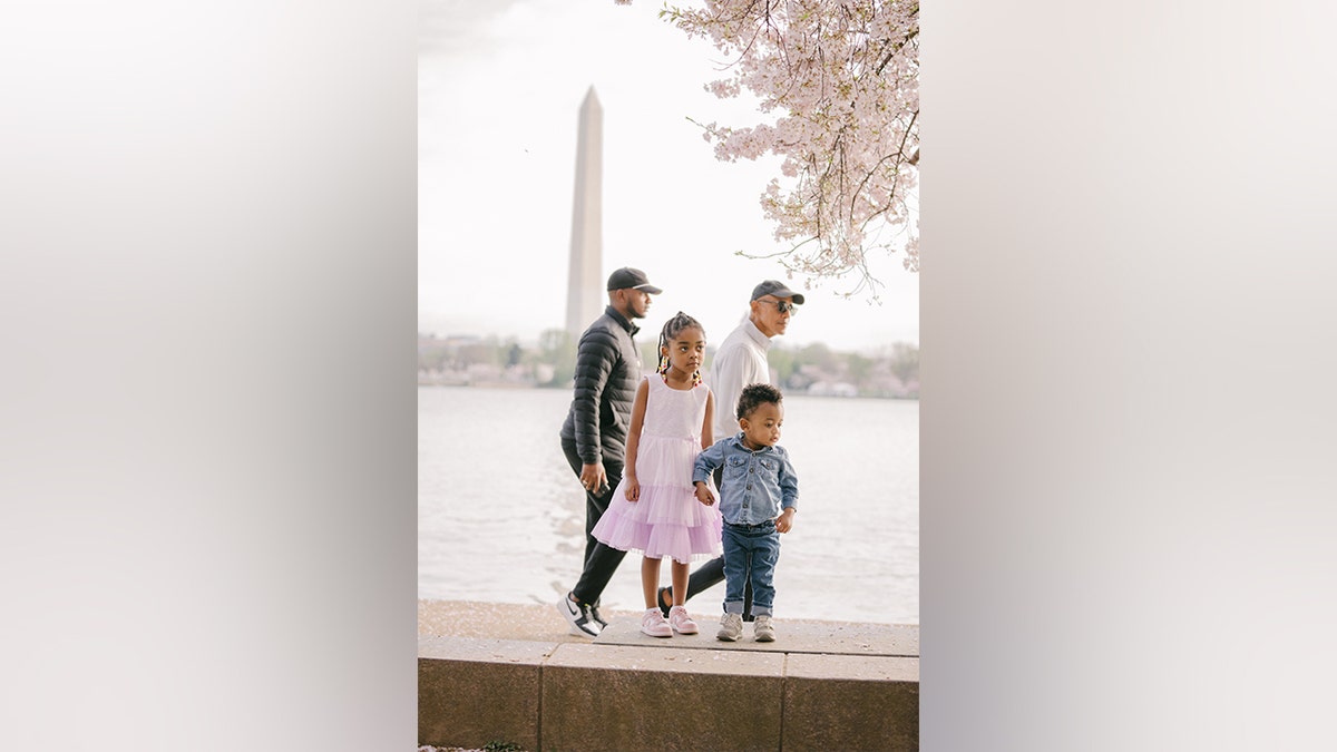 Obama walking behind children posing for a picture