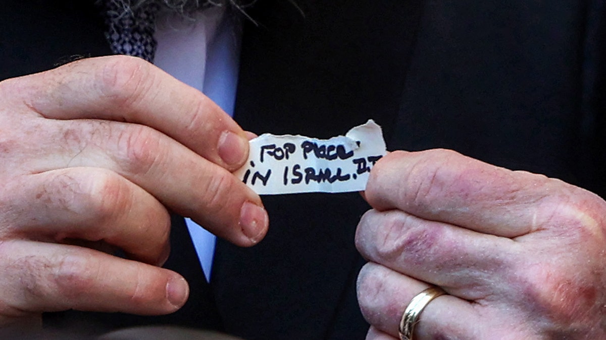 U.S. Ambassador to Israel Israel Mike Huckabee and Western Wall Rabbi Shmuel Rabinovitch hold up a note with a prayer from President Donald Trump