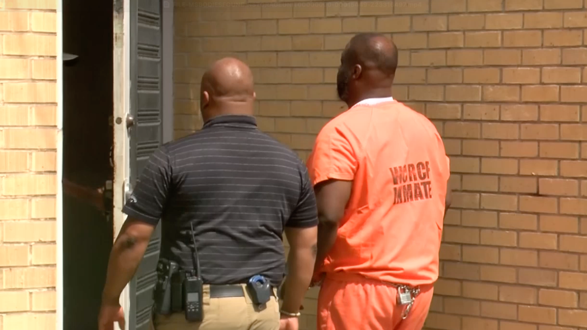 Albert Creath walking into jail wearing an orange jumpsuit.