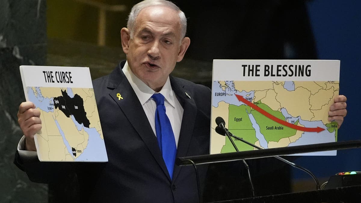 Prime Minister of Israel Benjamin Netanyahu hold signs as he addresses the 79th session of the United Nations General Assembly, Friday, Sept. 27, 2024. (AP Photo/Pamela Smith)