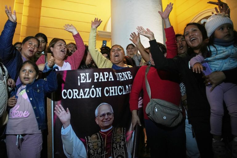 Parishioners hold up a banner that says in Spanish, "The pope has a Chiclayano heart."