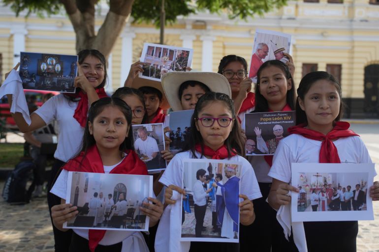 Children hold up pictures of Pope Leo XIV in Peru
