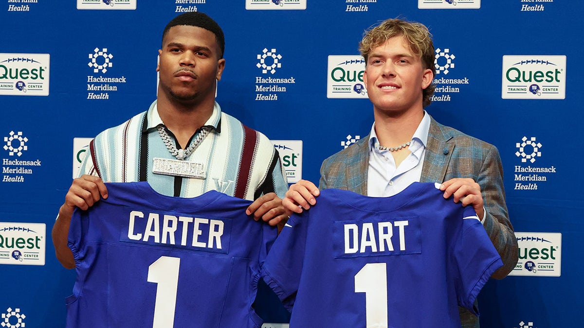 Abdul Carter and Jaxson Dart hold up Giants jerseys