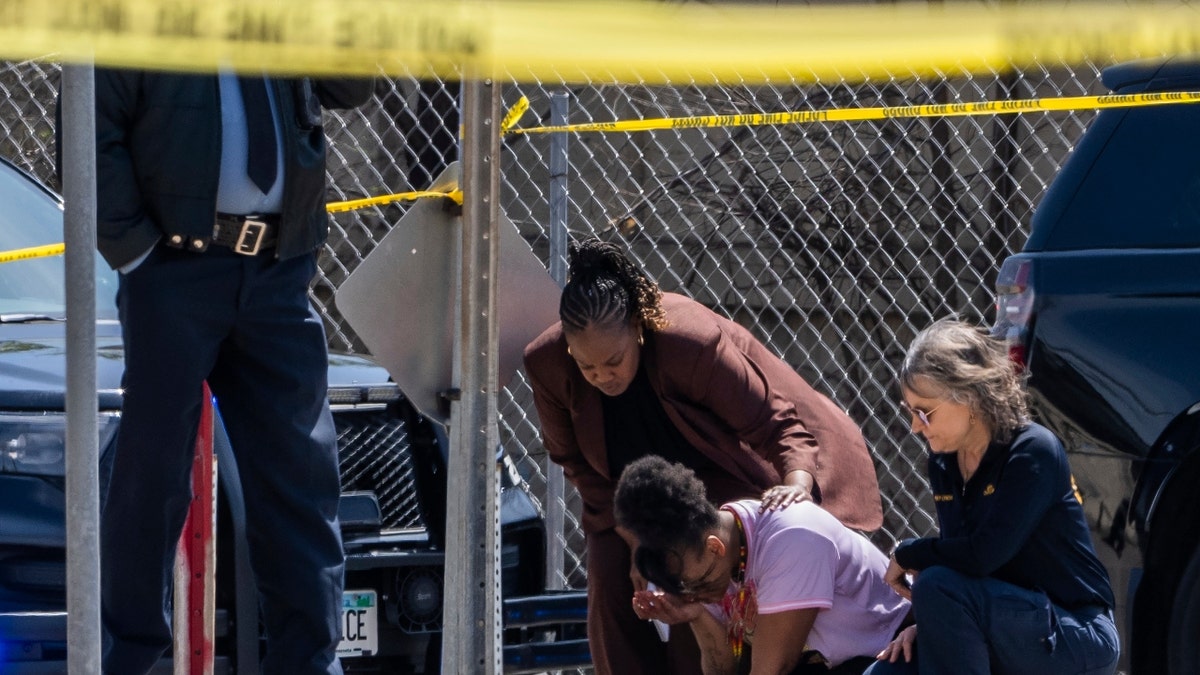 A police officer works on the scene as a bystander is shook up by the homicide in front of 2107 Cedar Ave S in Minneapolis, Minn., on Wednesday, April 30, 2025.
