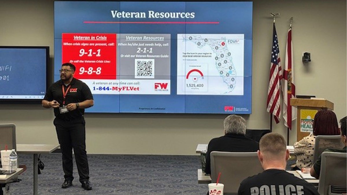 A trainer teachers to a group of volunteers learning about the nonprofit.