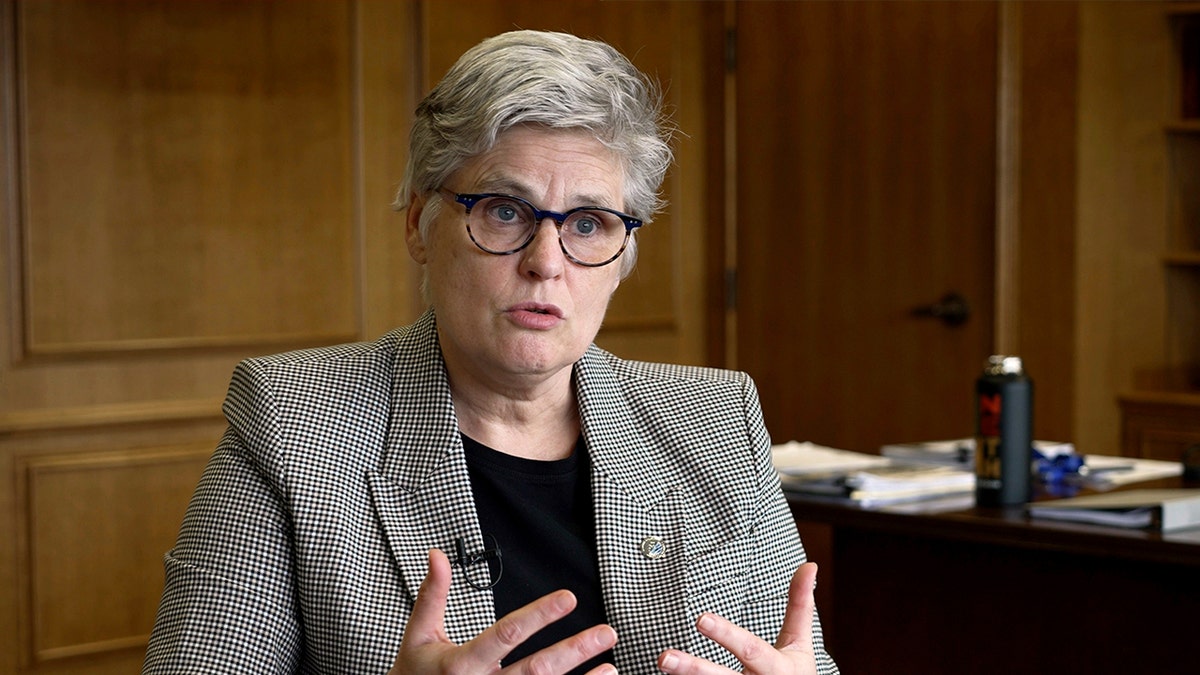 Mary Moriarty wears great suit making hand gestures while speaking