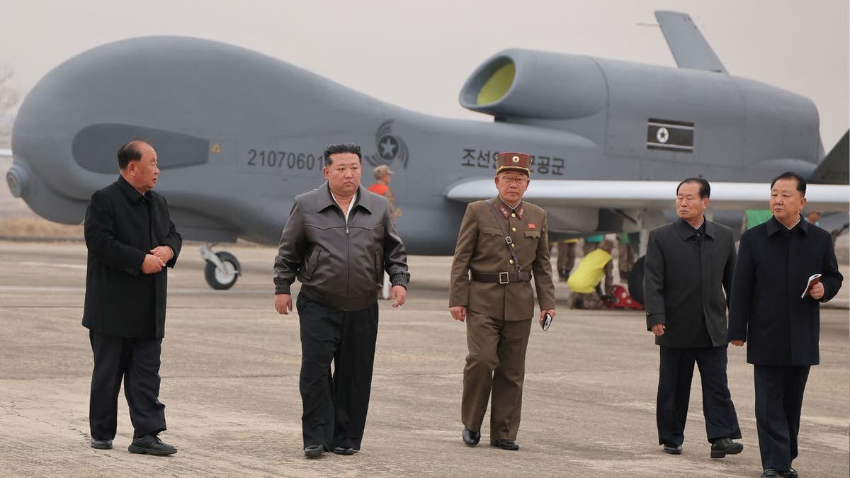North Korean leader Kim Jong Un walks alongside officials, while guiding defense science research projects