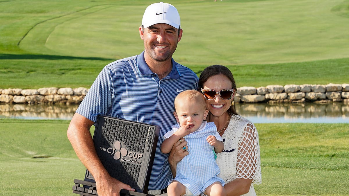 Scottie Scheffler poses with wife and child