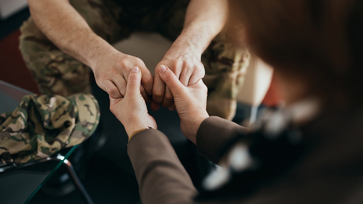 Military man and therapist in close-up during counseling session for mental health support.