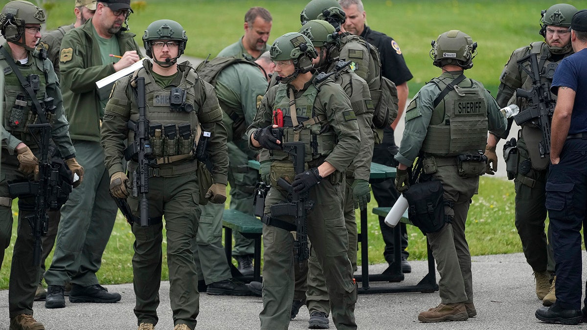 Law enforcement officers with the River Valley Tactical Team, prepare to visit the home of Vance Luther Boelter, who officials describe as a person of interest in the killing of Rep. Melissa Hortman and her husband, and the shooting of Sen. John Hoffman, near Green Isle, Minn., Saturday, June 14, 2025.