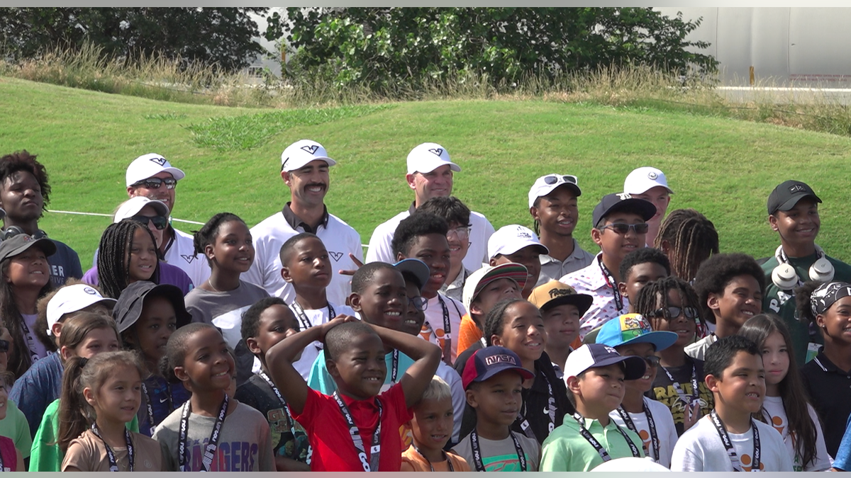 Kids from the greater DFW area pose for a picture with players from LIV Golf's HyFlyers GC.Â