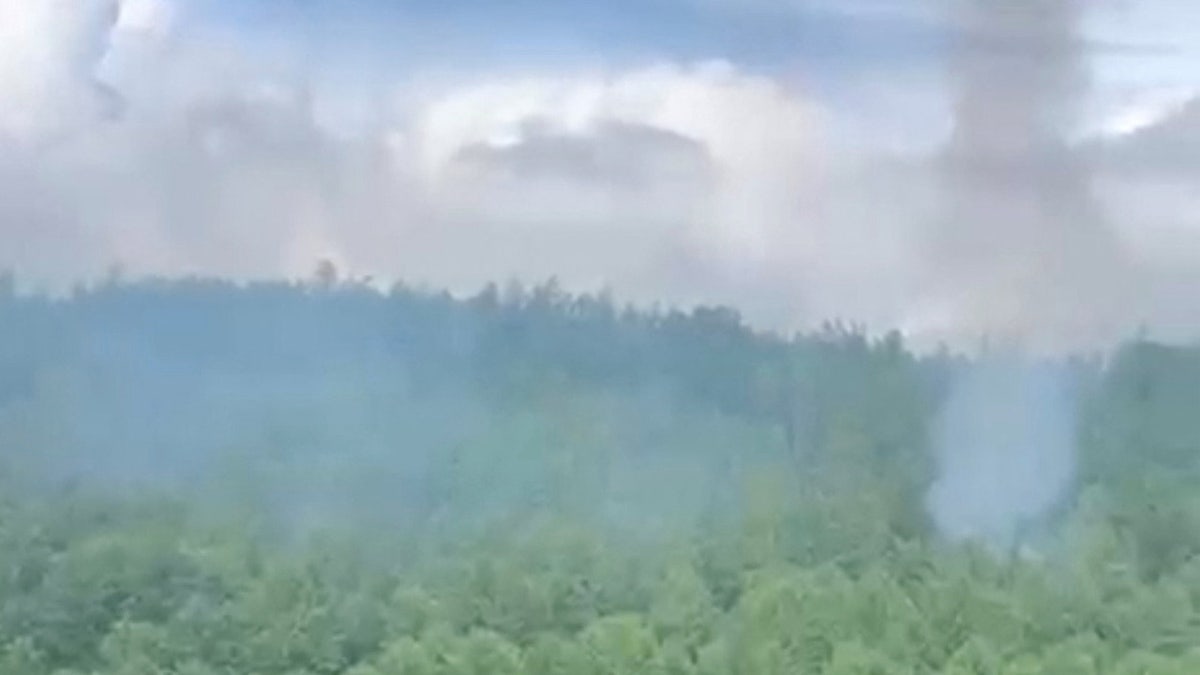 Smoke rises at the site of a plane crash in the Amur Region