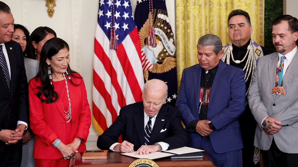 Then-President Joe Biden signing a document