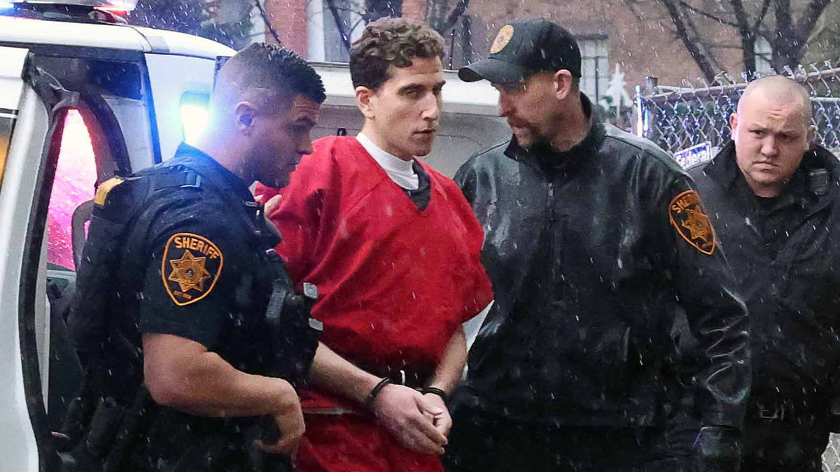 Bryan Kohberger, in shackles and a red jail jumpsuit, escorted by Pennsylvania deputies to a court hearing before his extradition to Idaho