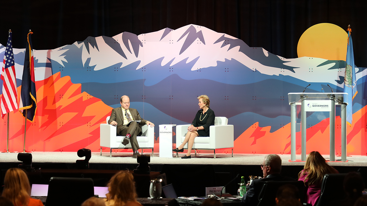 Gov. Jared Polis and Secretary Linda McMahon on stage