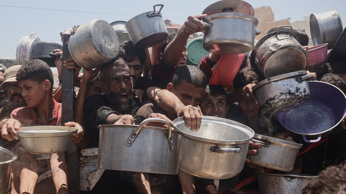 Palestinian children queue for a portion of hot food distributed by a charity kitchen at the Nuseirat refugee camp in the central Gaza Strip on July 15, 2025. (Photo by Eyad BABA / AFP) (Photo by EYAD BABA/AFP via Getty Images)