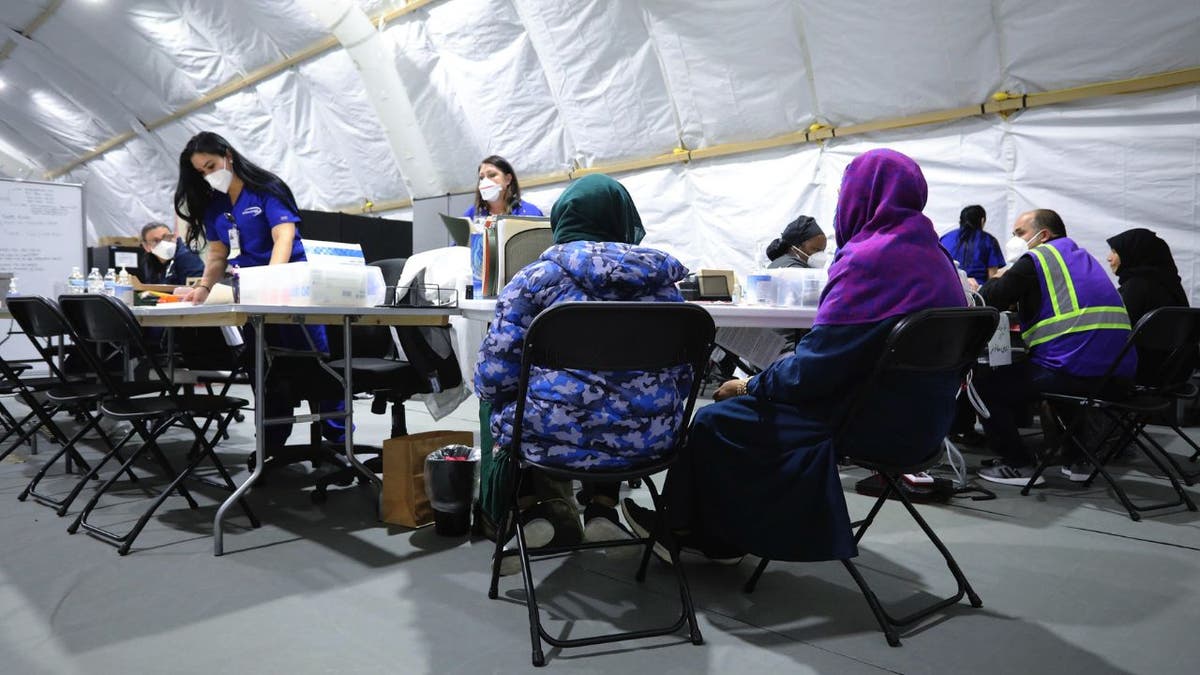 Afghan refugee women register to be seen by a doctor at a military base