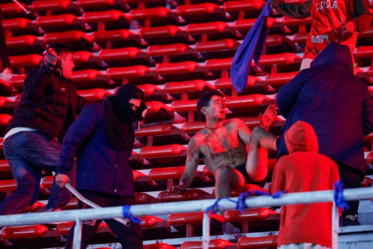 Fans clash in the stands during the CONMEBOL Copa Sudamericana round of 16 soccer match between Independiente and Universidad de Chile, in Avellaneda, Argentina